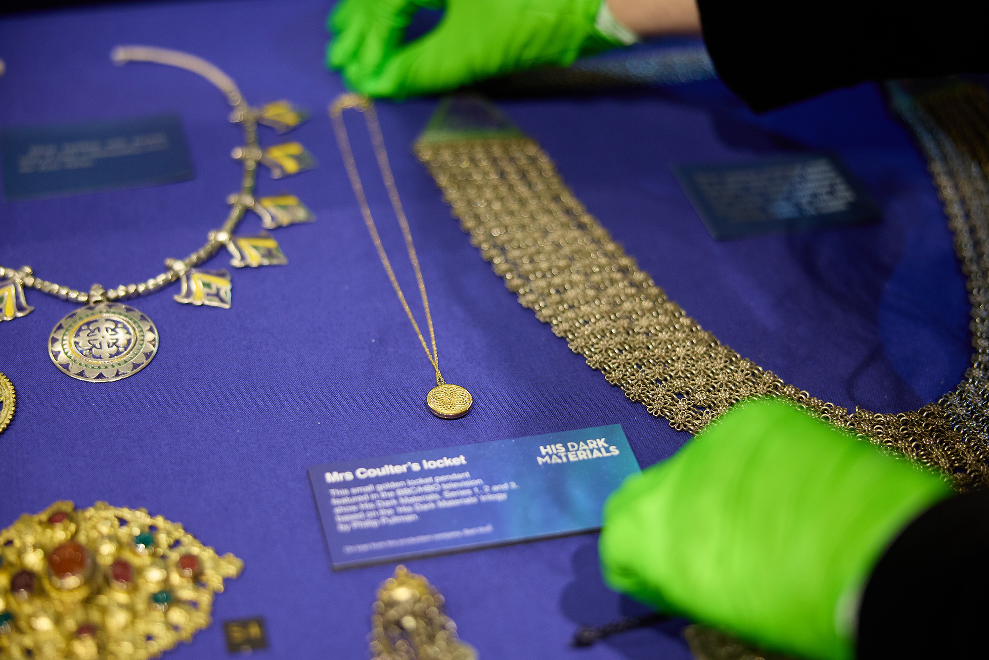 Penny-sized gold disc on a chain on a blue background